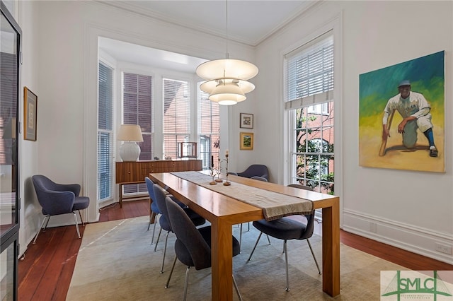 dining space featuring hardwood / wood-style floors and ornamental molding