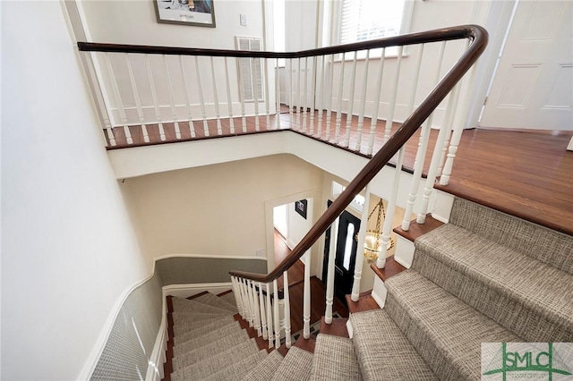 staircase featuring baseboards and wood finished floors