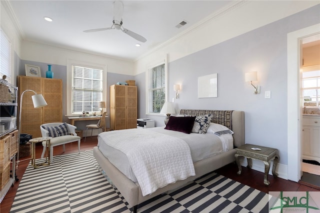 bedroom featuring dark hardwood / wood-style flooring, connected bathroom, ceiling fan, and ornamental molding