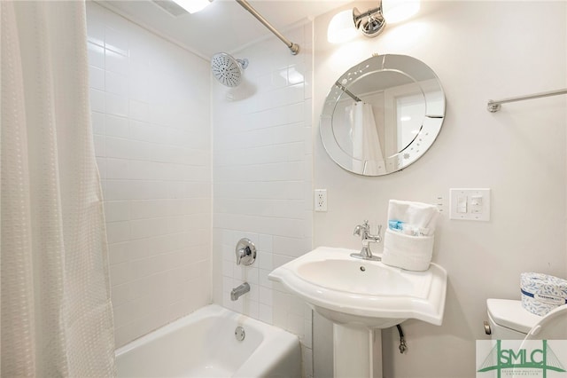 bathroom featuring shower / bath combination with curtain and toilet