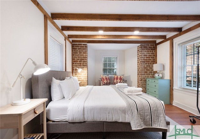 bedroom featuring beamed ceiling and wood-type flooring