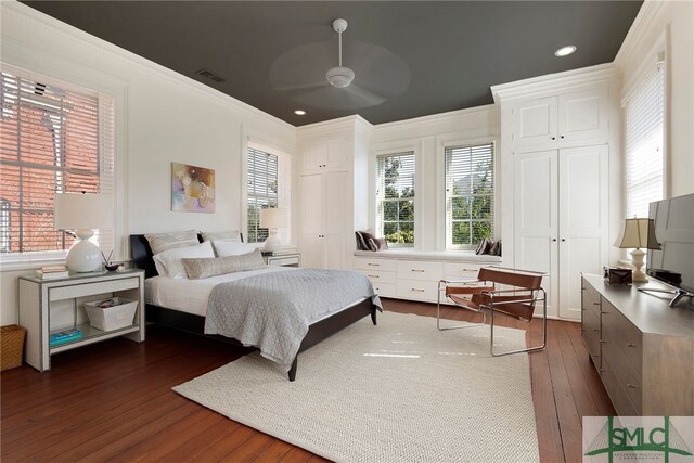 bedroom with dark hardwood / wood-style floors, ceiling fan, and ornamental molding