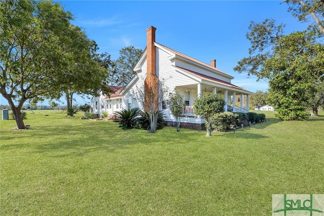 view of side of home featuring a lawn and a porch