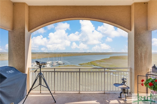 balcony featuring area for grilling and a water view