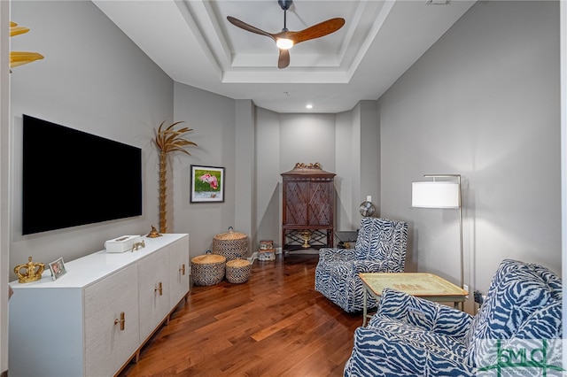 sitting room with a tray ceiling, ceiling fan, and hardwood / wood-style floors