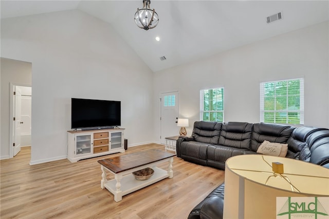 living room featuring a chandelier, hardwood / wood-style floors, and high vaulted ceiling