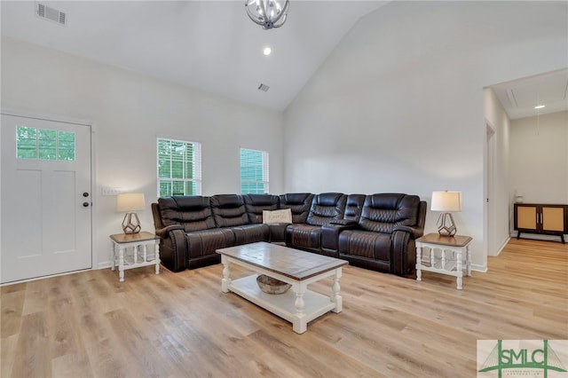 living room featuring high vaulted ceiling and light hardwood / wood-style flooring