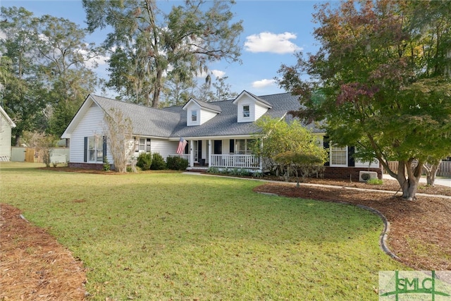 cape cod house with a front lawn and covered porch