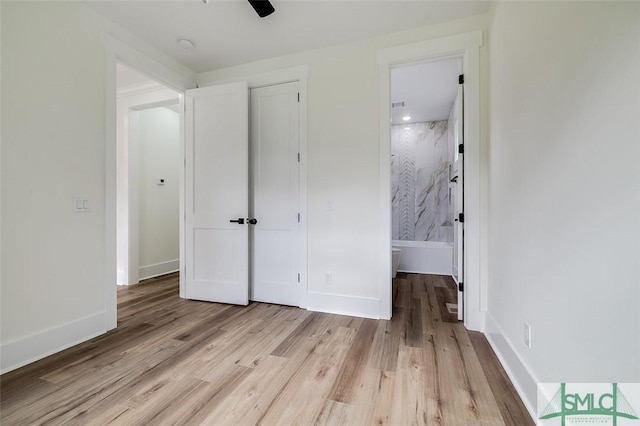 unfurnished bedroom featuring light hardwood / wood-style floors, ensuite bath, and ceiling fan