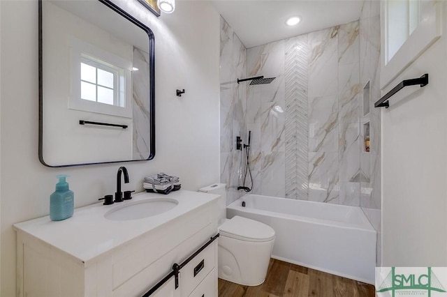 full bathroom with toilet, vanity, hardwood / wood-style floors, and tiled shower / bath combo