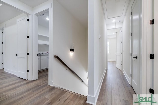 hall featuring light wood-type flooring and sink