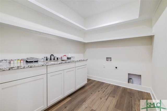 clothes washing area with hookup for a washing machine, electric dryer hookup, dark hardwood / wood-style flooring, sink, and cabinets