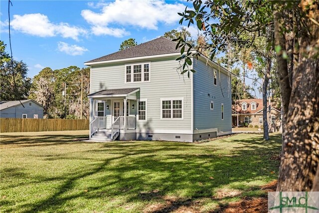 rear view of property featuring a lawn