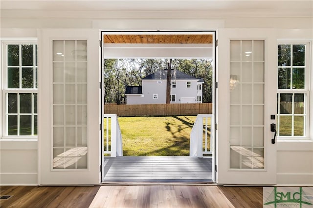 doorway featuring ornamental molding and hardwood / wood-style floors