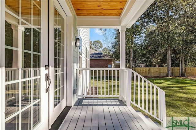 wooden deck featuring a lawn and french doors