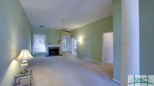 carpeted living room with a brick fireplace and ceiling fan