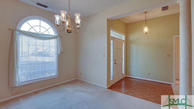 foyer entrance with a notable chandelier, a textured ceiling, and light parquet flooring