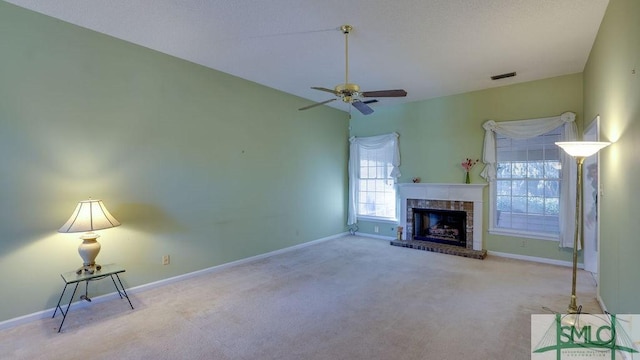 unfurnished living room featuring ceiling fan, light colored carpet, and a brick fireplace