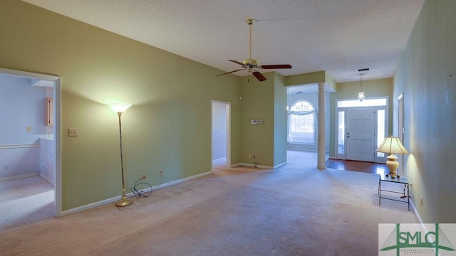 unfurnished living room featuring light carpet, ornate columns, and ceiling fan