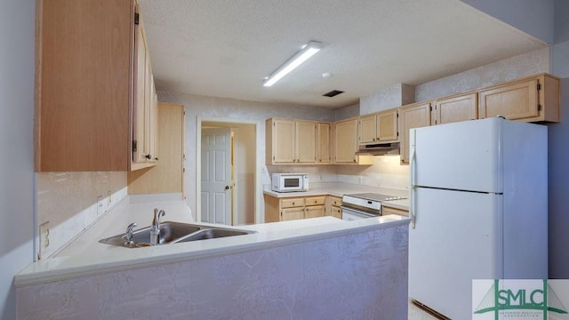 kitchen with kitchen peninsula, sink, white appliances, and light brown cabinets