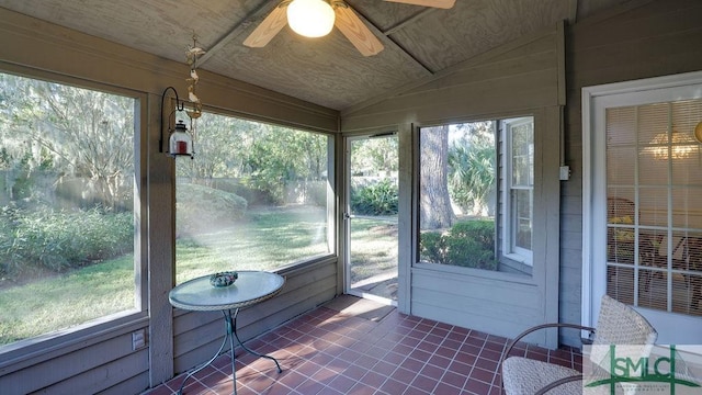 unfurnished sunroom with ceiling fan, a healthy amount of sunlight, and lofted ceiling