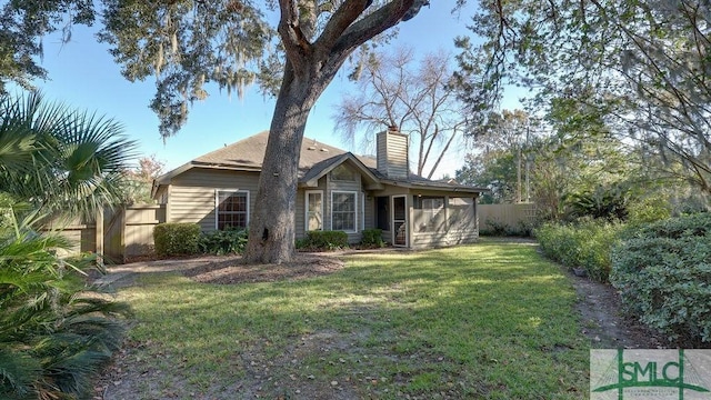 rear view of property with a yard