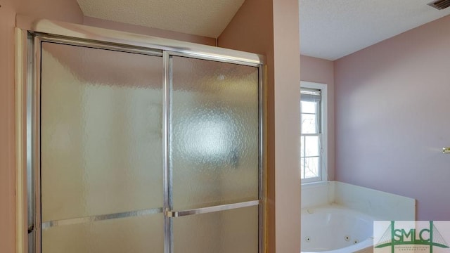 bathroom featuring independent shower and bath and a textured ceiling