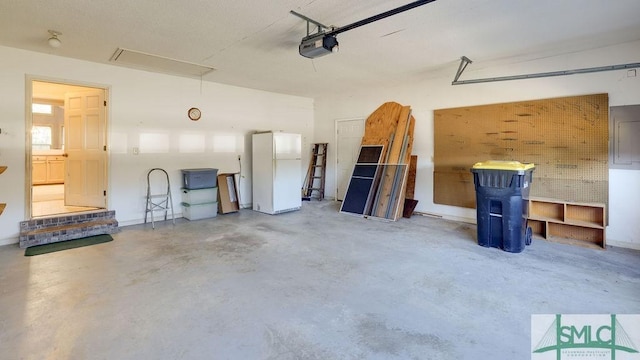 garage featuring white fridge and a garage door opener