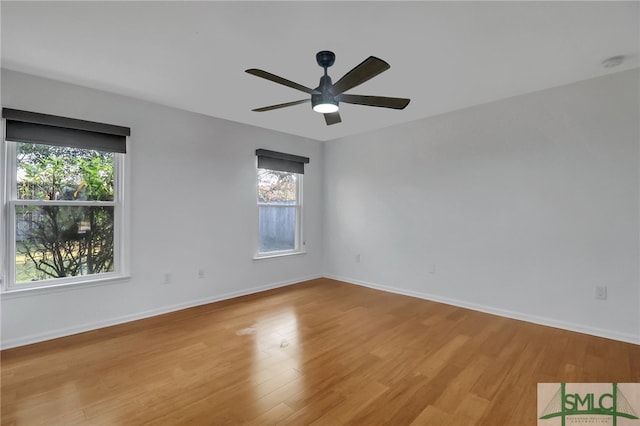 spare room with light wood-type flooring, plenty of natural light, and ceiling fan