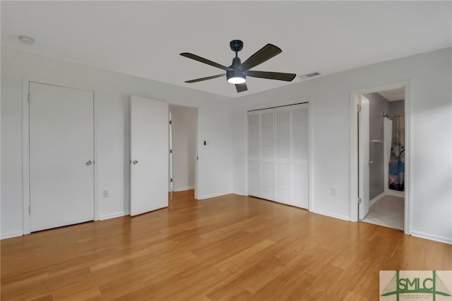 unfurnished bedroom featuring hardwood / wood-style floors, ensuite bathroom, and ceiling fan