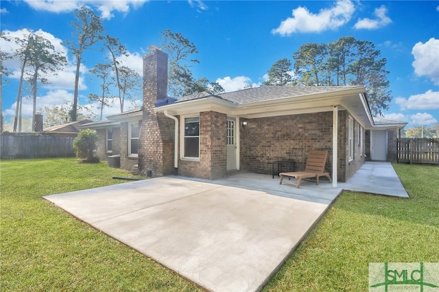 back of house with a yard and a patio