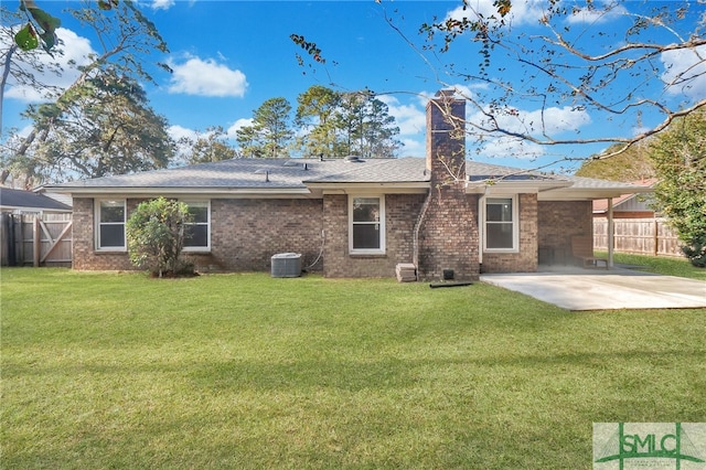 rear view of property with a lawn, cooling unit, and a patio