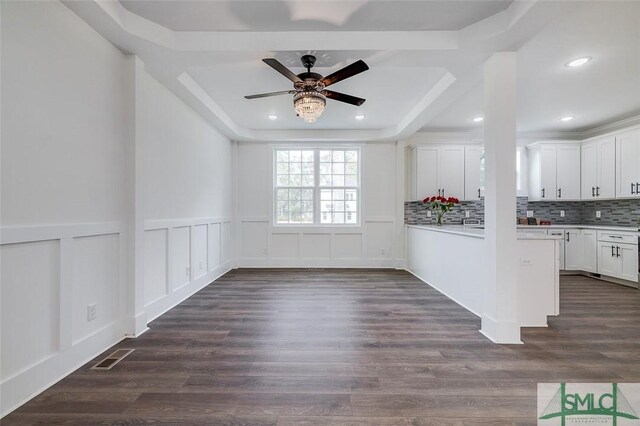 interior space featuring dark hardwood / wood-style floors, a raised ceiling, and ceiling fan