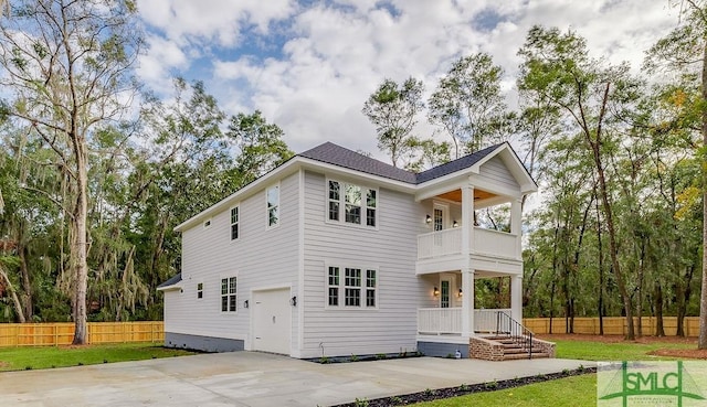 back of property with a balcony and a garage