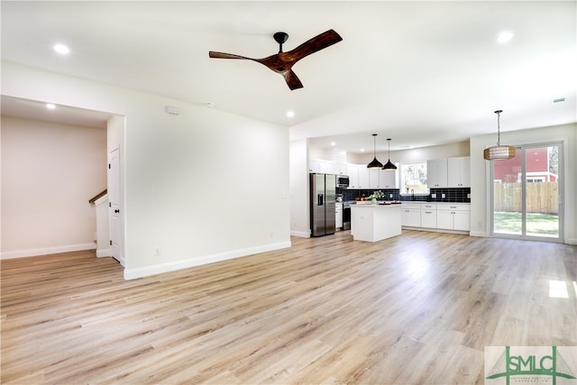 unfurnished living room featuring ceiling fan and light hardwood / wood-style flooring