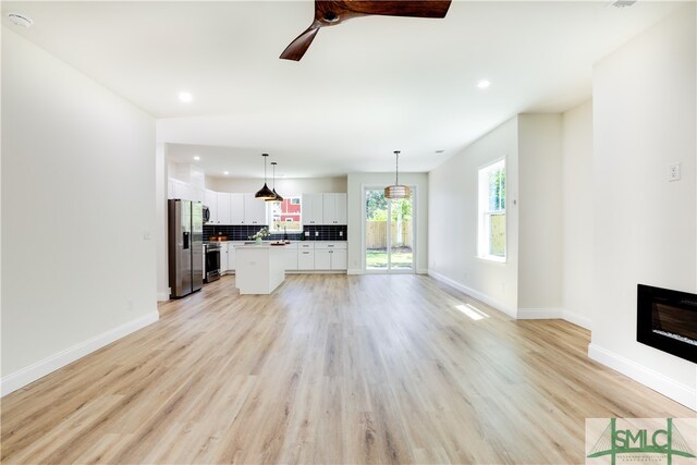 unfurnished living room featuring ceiling fan and light hardwood / wood-style flooring