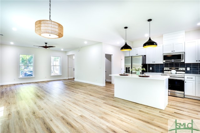 kitchen featuring light wood-type flooring, stainless steel appliances, ceiling fan, white cabinetry, and a kitchen island