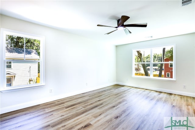 spare room with ceiling fan, a healthy amount of sunlight, and light hardwood / wood-style flooring