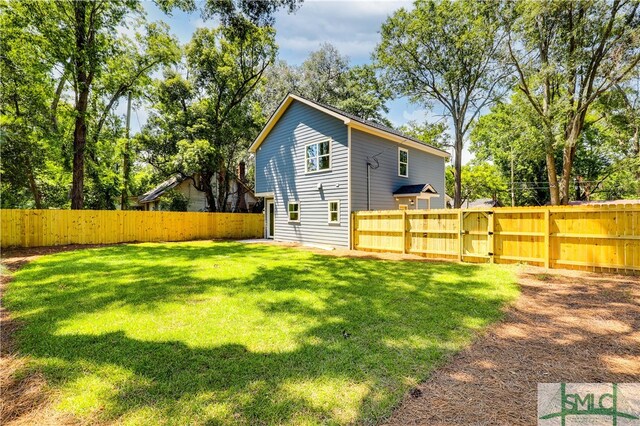 rear view of property featuring a yard