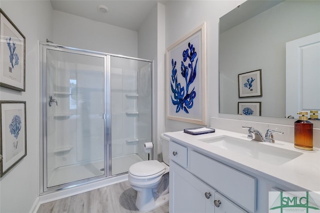 bathroom with toilet, hardwood / wood-style floors, vanity, and walk in shower