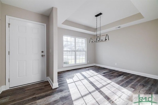 foyer with dark hardwood / wood-style floors and a tray ceiling