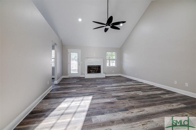 unfurnished living room featuring dark hardwood / wood-style floors, ceiling fan, a fireplace, and high vaulted ceiling