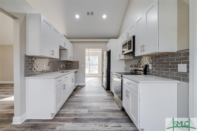 kitchen featuring white cabinetry, sink, decorative backsplash, appliances with stainless steel finishes, and light wood-type flooring