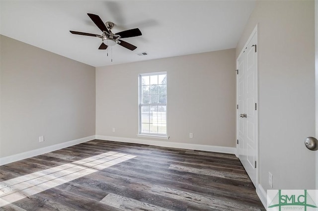 empty room with ceiling fan and dark hardwood / wood-style flooring