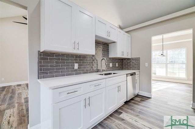 kitchen featuring white cabinetry, sink, stainless steel dishwasher, vaulted ceiling, and light wood-type flooring