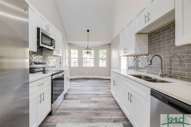 kitchen featuring backsplash, stainless steel appliances, sink, light hardwood / wood-style flooring, and white cabinetry