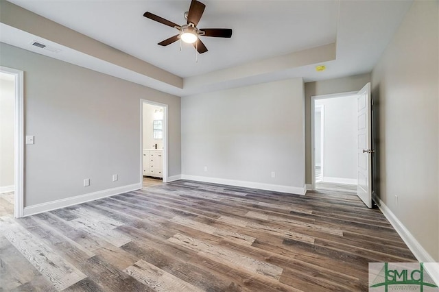 spare room featuring a tray ceiling, ceiling fan, and hardwood / wood-style floors