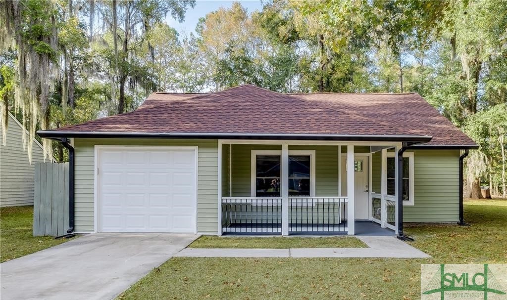 ranch-style house featuring a front lawn, a porch, and a garage