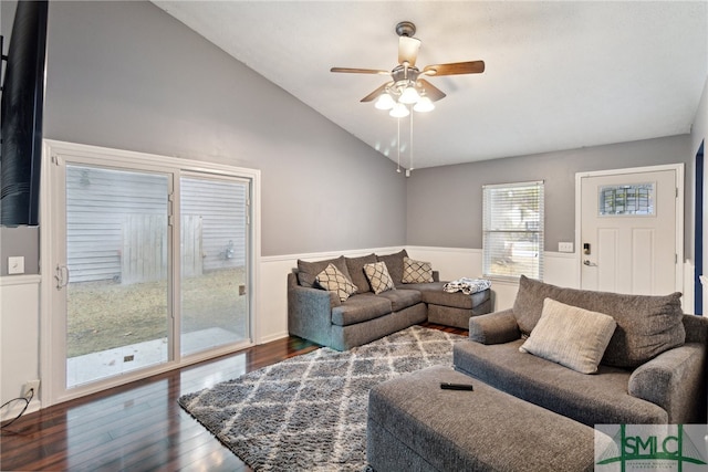 living room with ceiling fan, dark wood-type flooring, and vaulted ceiling