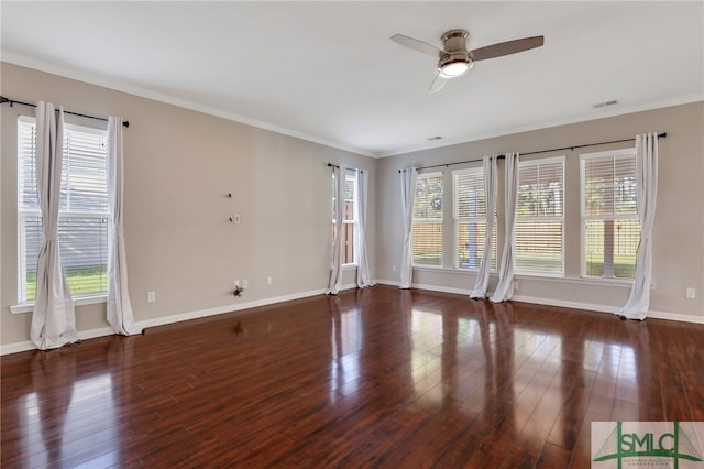 empty room with dark hardwood / wood-style floors, a healthy amount of sunlight, crown molding, and ceiling fan